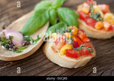 Bruschetta with tomato, paprika, garlic, basil over a  wooden background Stock Photo