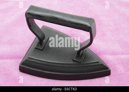 Ancient coal iron on a pink cloth Stock Photo