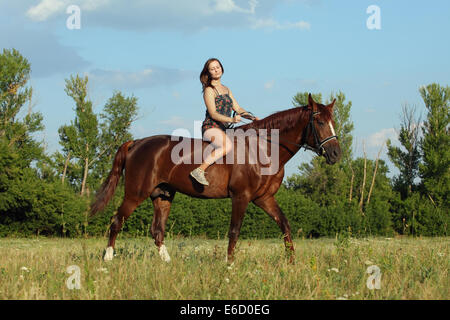 Girl and her horse enjoying the day of summer Stock Photo
