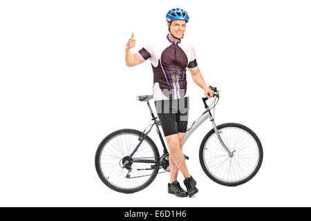 Young male biker giving a thumb up with his bicycle behind him Stock Photo