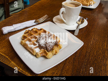 Delicious sweet waffle and coffee in a waffle shop in Bruges, Belgium. A  perfect way to start the day! Stock Photo
