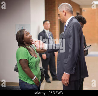 Ferguson, Mo. 20th Aug, 2014. United States Attorney General Eric Holder, right, talks with Charnell Hurn, 20, left, a student at St. Louis Community College Florissant Valley, Wednesday, Aug. 20, 2014 in Ferguson, Mo. Holder traveled to the St. Louis-Area to oversea the federal government's investigation into the shooting of 18-year-old Michael Brown by a police officer on Aug. 9th. Holder promised a 'fair and thorough' investigation into the fatal shooting of a young black man, Michael Brown Credit:  dpa picture alliance/Alamy Live News Stock Photo