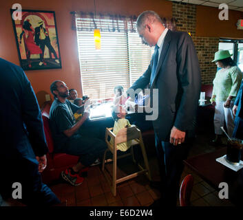 Ferguson, Mo. 20th Aug, 2014. United States Attorney General Eric Holder, right, touches the forehead of Yusayrah Jones, 2, has he arrives at Drake's Place Restaurant for a meeting with community leaders, Wednesday, Aug. 20, 2014 in Florrissant, Mo. Holder traveled to the Ferguson to oversee the federal governmentís investigation into the shooting of 18-year-old Michael Brown by a police officer on Aug. 9th. Holder promised a 'fair and thorough' investigation into the fatal shooting of a young black man, Michael Brown Credit:  dpa picture alliance/Alamy Live News Stock Photo