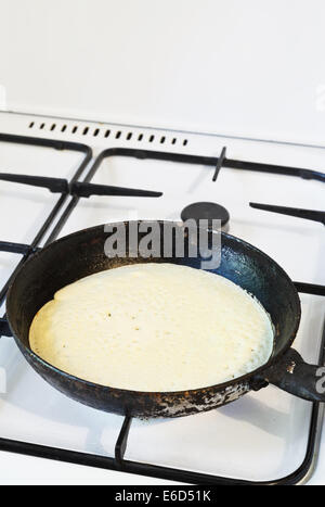 baking pancake on frying pan on gas stove Stock Photo