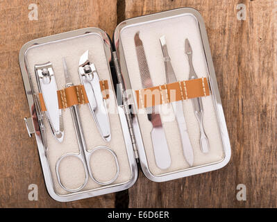 Classic metal kit of nail scissors and manicure tools on wooden background Stock Photo