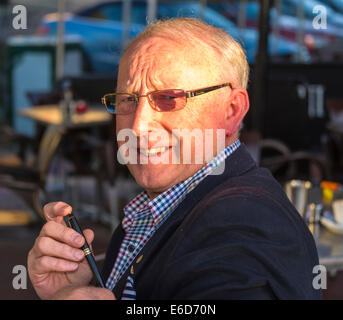 Two middle aged gentlemen having coffee seated at cafe Stock Photo