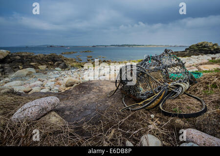 An old lobster pot is washed up on the shore of the uninhabited island of Annet, on the Isles of Scilly. Stock Photo