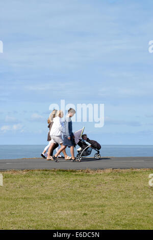 Family with young child in pushchair on coastal path in Blackpool, Lancashire Stock Photo