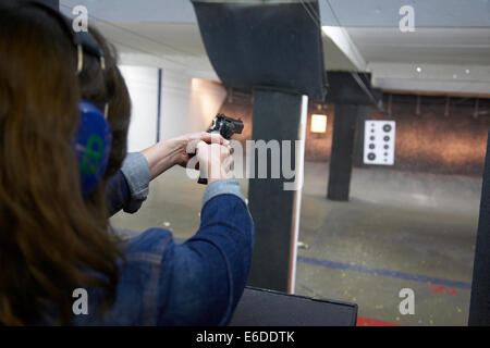 Young woman shooting a handgun at a shooting range in Minneapolis USA. Stock Photo