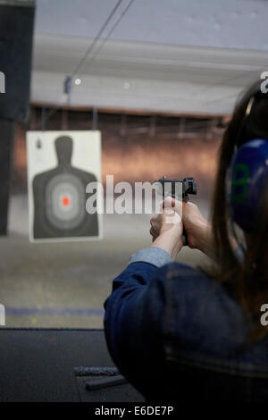 Young woman shooting a handgun at a shooting range in Minneapolis USA. Stock Photo