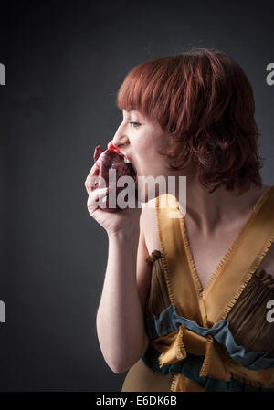 woman eating a heart. Based on sonnet 'A ciascun alma presa' of Dante Alighieri Stock Photo