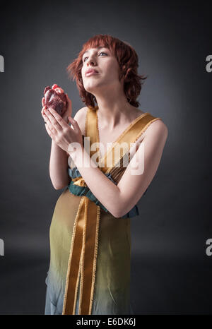 Woman with heart in her hand. Based on sonnet 'A ciascun alma presa' of Dante Alighieri Stock Photo