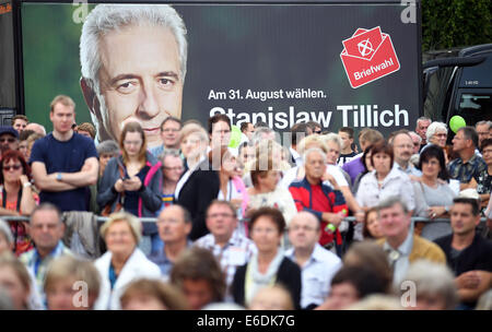 Grimma, Germany. 21st Aug, 2014. Visitors of an election campaign event for the Saxon state elections stand in front of a poster for Saxon Premier Tillich (CDU) in Grimma, Germany, 21 August 2014. The state elections will take place on 31 August 2014. Photo: Jan Woitas/dpa/Alamy Live News Stock Photo