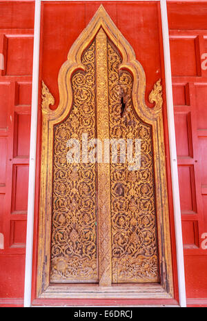 This antique door is located at Wat Yai Suwannaram in Petchburi, Thailand. The damage on the upper right hand of the door was ax Stock Photo