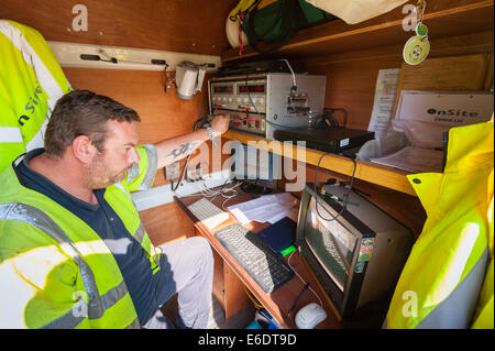 A worker watches the footage in his van on a computer from a remote control camera with wheels which drives up the sewer pipes c Stock Photo