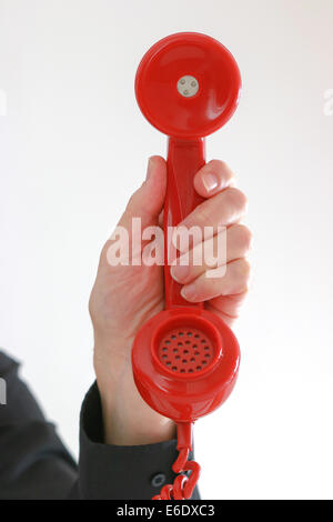 Man's hand holding old red telephone receiver. Stock Photo