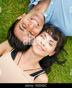 Couple lying on grass together Stock Photo