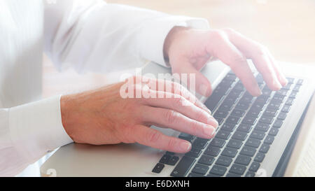 Mature man typing on laptop keyboard. Close-up. Stock Photo