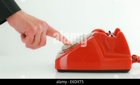 Red retro telephone, man dialing. Stock Photo
