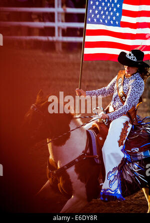 Rodeo Queen carrying American Flag on horseback during National Anthem, Chaffee County Fair & Rodeo, Colorado, USA Stock Photo