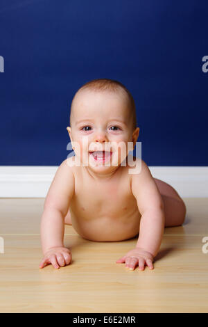 9 month old baby boy holding his head up and smilling, showing his two lower incisors. Stock Photo
