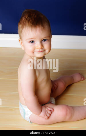 Happy 9 month old baby boy sitting up Stock Photo