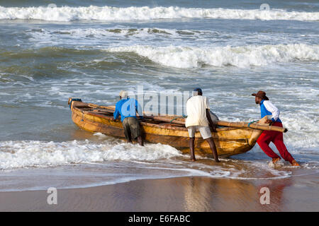 Fishermen launching a fishing boat at Prampram, Greater Accra, Ghana, Africa Stock Photo