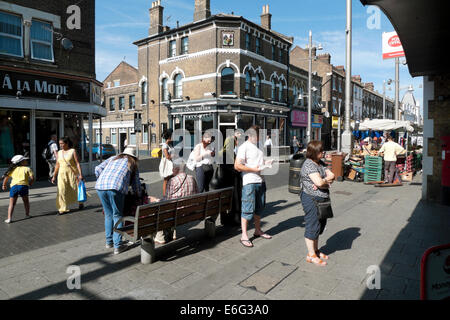 People queuing on Walthamstow HIgh Street to use an ATM bank cashpoint hole-in-the-wall money machine London UK KATHY DEWITT Stock Photo