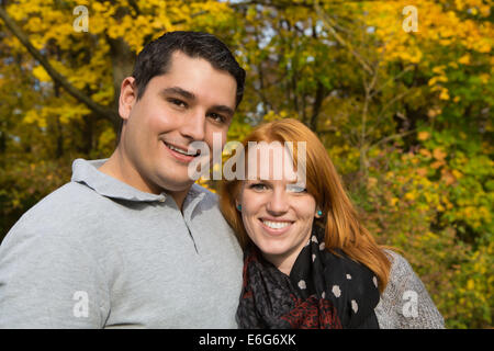 Happy young couple in autumn making a walk in the forest. Stock Photo