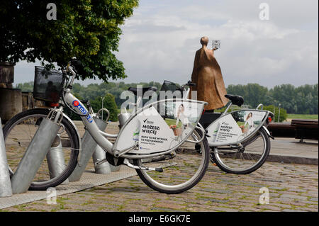 Free public Bicycle and Monument of Madame Curie at the bank of river Vistuka  in Warsaw, Poland, Europe Stock Photo