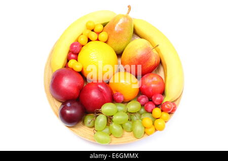 Fresh ripe fruits lying on wooden plate, desk of fruits, concept for healthy eating. Isolated on white background Stock Photo