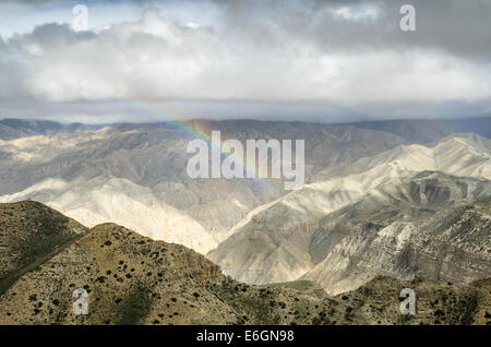 Real-colored rainbow in the high mountain sky after the distant rain along the route from Samar to Gemi villages of Nepal Stock Photo