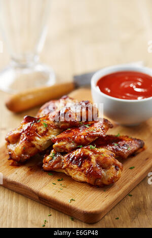 Chicken wings with sriracha sauce on wooden table Stock Photo