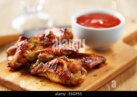 Chicken wings with sriracha sauce on wooden table Stock Photo