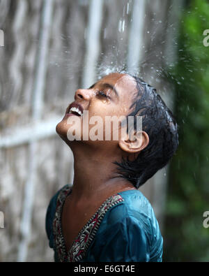 Dhaka, Bangladesh. 23rd Aug, 2014. Slum children enjoying rain in Dhaka.Dhaka is the second most vulnerable city to serious flooding among nine coastal cities globally and will remain so until 2100 unless measures to counter the threat are taken, an international study suggests Credit:  Zakir Hossain Chowdhury/ZUMA Wire/Alamy Live News Stock Photo