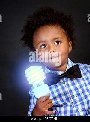 Little genius with illuminated lamp in hand isolated on black background, african boy is a great physics, back to school concept Stock Photo