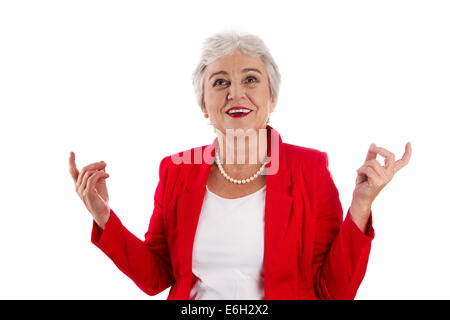 Happy isolated older woman in red cheerful and happy about her success. Also a concept for senior manager or employees. Stock Photo
