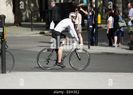 A cyclist riding around a roundabout at Trafalgar Square, London. Stock Photo