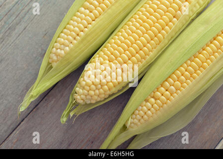 Raw corn cobs on wooden background closeup Stock Photo