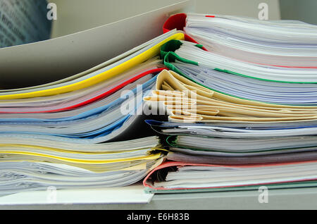 Red, green, blue and yellow office folders with boxes on the gray shelf Stock Photo