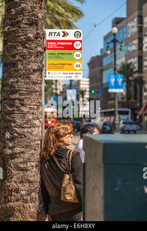 Woman waits at streetcar stop on Canal Street in downtown New Orleans, Louisiana Stock Photo