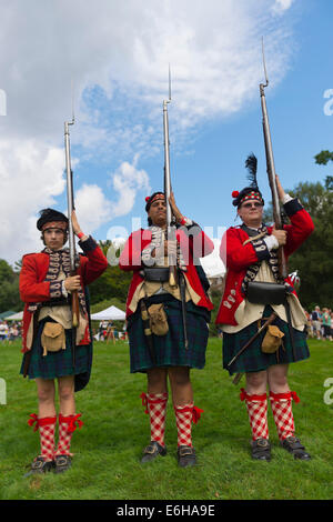 Old Westbury, New York, U.S. - August 23, 2014 - L-R, TIM NORTON, of CT, AARON BOATRIGHT, of CT, and CONRAD BENDER IV, of NJ, are American Revolution re-enactors portraying members of the 42nd Royal Regiment of Foote, at the 54th Annual Long Island Scottish Festival and Highland Games, co-hosted by L. I. Scottish Clan MacDuff, at Old Westbury Gardens. The regiment, The Black Watch, was raised in the Scottish Highlands in 1740 and fought for the British. Credit:  Ann E Parry/Alamy Live News Stock Photo