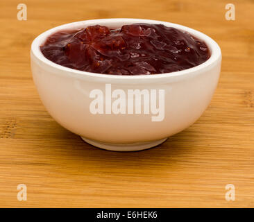 Small white pot of strawberry Jam on a wooden board Stock Photo