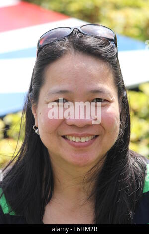 Head and shoulders of a pretty, mature, Asian woman posing for photos, with a nice smile. Stock Photo
