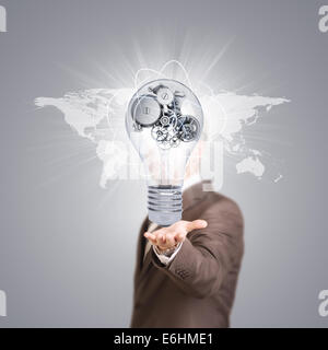Businessman in a suit hold bulb with metal gears Stock Photo