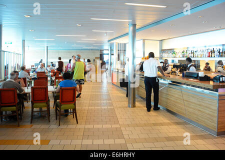 Passengers & staff interior of cruise ship cafeteria deck with breakfast buffet tables with bar counter open aboard a large Mediterranean cruise liner Stock Photo