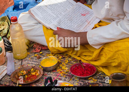 A Hindu priest, wearing traditional clothing, performing a religious ritual at a market in Kathmandu, Nepal. Stock Photo