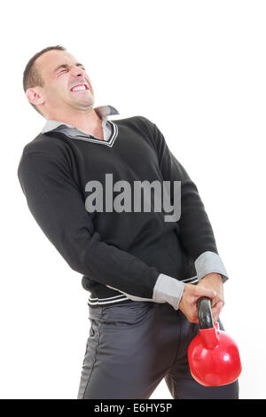 business man in black sweater with shirt and pants lifting red dubell with face expression Stock Photo