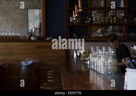 Bartender behind the bar at a modern, sophisticated restaurant in Los Angeles. Stock Photo