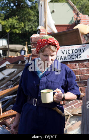 Land girl having a cuppa after the Bombing of Victory Gardens in World War Two Reenactment Stock Photo